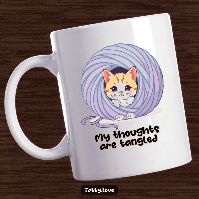 Funny cat mug showing a curious kitten peeking from behind an enormous ball of colorful yarn, embodying playful mischief.